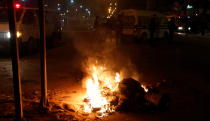 <p>Police vehicles stop in front of burning tires set up by protesters during demonstrations against rising prices and tax increases, in Tunis, Tunisia, Jan. 8, 2018. (Photo: Zoubeir Souissi/Reuters) </p>