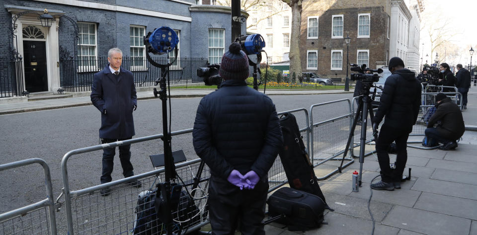 Journalists keep their distance as they report from Downing Street in London after it was announced that British Prime Minister Boris Johnson has tested positive for the new coronavirus, Friday, March 27, 2020. Johnson's office said Friday that he was tested after showing mild symptoms, Downing Street says Johnson is self-isolating and continuing to lead the country's response to COVID-19. (AP Photo/Frank Augstein)