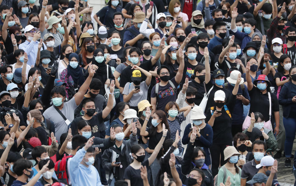 Pro-democracy demonstrators flash three-fingered salute during an anti-government protest, at Victory Monument in Bangkok, Thailand, Sunday, Oct. 18, 2020. Thai police on Sunday declined to say whether they were taking a softer approach toward student anti-government demonstrations, after several mass rallies attracting thousands of protesters ended peacefully in Bangkok on Saturday. (AP Photo/Sakchai Lalit)