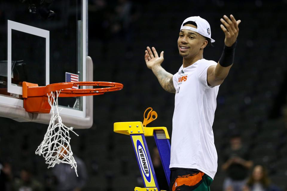 Mar 26, 2023; Kansas City, MO, USA;  Miami Hurricanes guard Isaiah Wong (2) cuts down a piece of the net after defeating the Texas Longhorns at the T-Mobile Center. Mandatory Credit: William Purnell-USA TODAY Sports