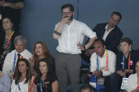 Chile's President Gabriel Boric watches swimming finals at the Pan American Games in Santiago, Chile, Monday, Oct. 23, 2023. Sitting left is Chile's Sports Minister Jaime Pizarro. (AP Photo/Silvia Izquierdo)