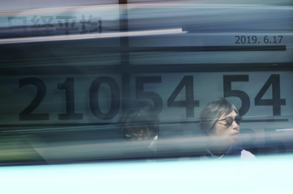 Men stand in front of an electronic stock board showing Japan's Nikkei 225 index at a securities firm in Tokyo Monday, June 17, 2019. Asian shares were mostly higher Monday amid a wait-and-see attitude about the direction of interest rates and the trade dispute between the U.S. and China. (AP Photo/Eugene Hoshiko)