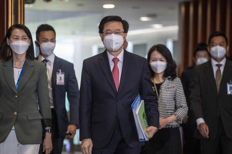 Hong Kong Chief Executive John Lee, center, enters the chamber of the Legislative Council in Hong Kong, Wednesday, Oct. 19, 2022. Hong Kong's leader on Wednesday unveiled a new visa scheme to woo global talent, as the city seeks to stem a brain drain that has risked its status as an international financial center. (AP Photo/Vernon Yuen)