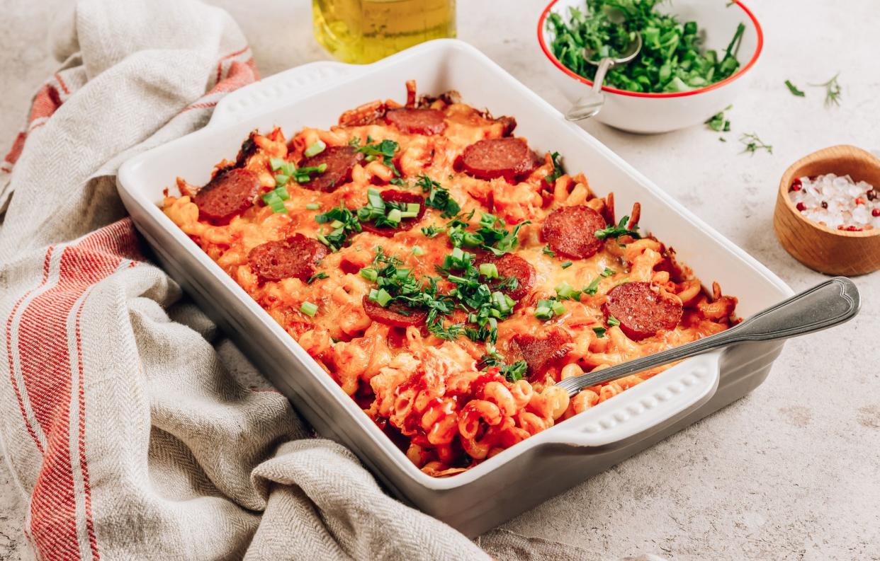 Pasta baked in a tomato pesto sauce with cheese, herbs and pepperoni. Spicy Pizza Pasta on concrete background. Selective focus