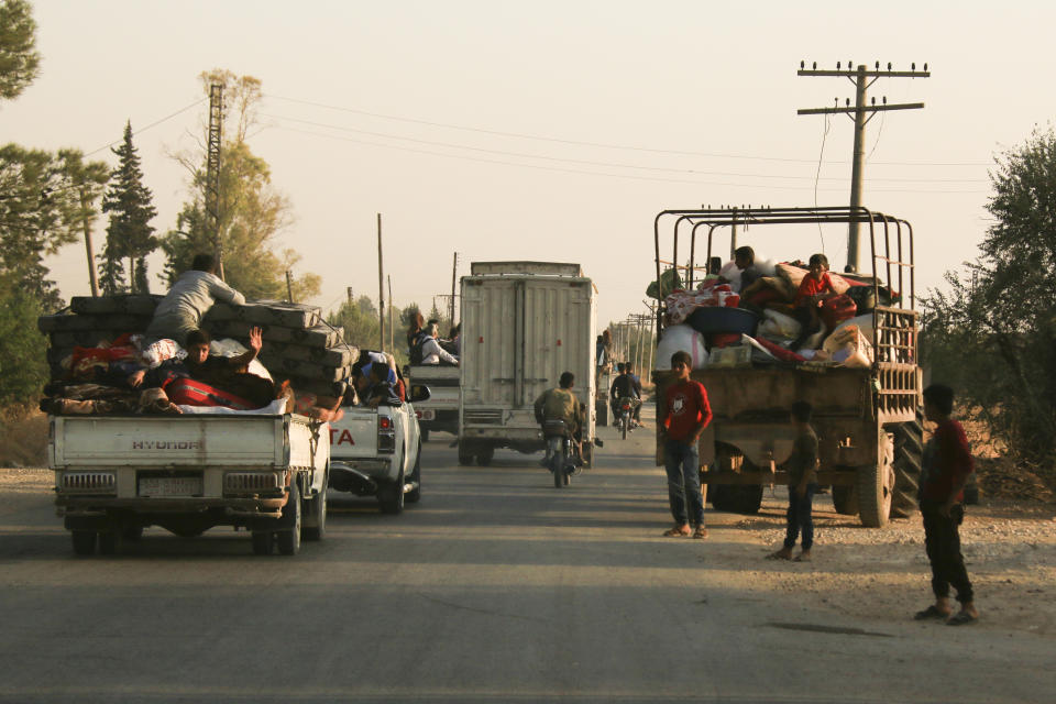 Syrians flee shelling by Turkish forces in Ras al Ayn, northeast Syria, Wednesday, Oct. 9, 2019. Turkish President Recep Tayyip Erdogan announced Wednesday the start of a Turkish military operation against Kurdish fighters in northeastern Syria. (AP Photo/Baderkhan Ahmad)