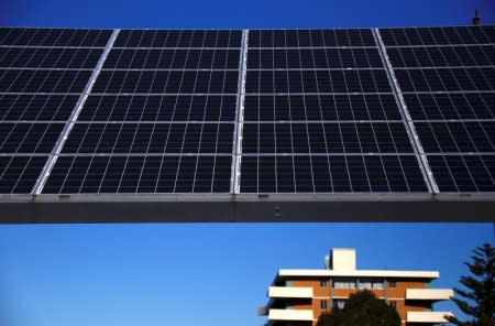 FILE PHOTO: A solar array, a linked collection of solar panels, can be seen in front of a residential apartment block in the Sydney suburb of Chatswood in Australia, July 28, 2017.      REUTERS/David Gray/File Photo