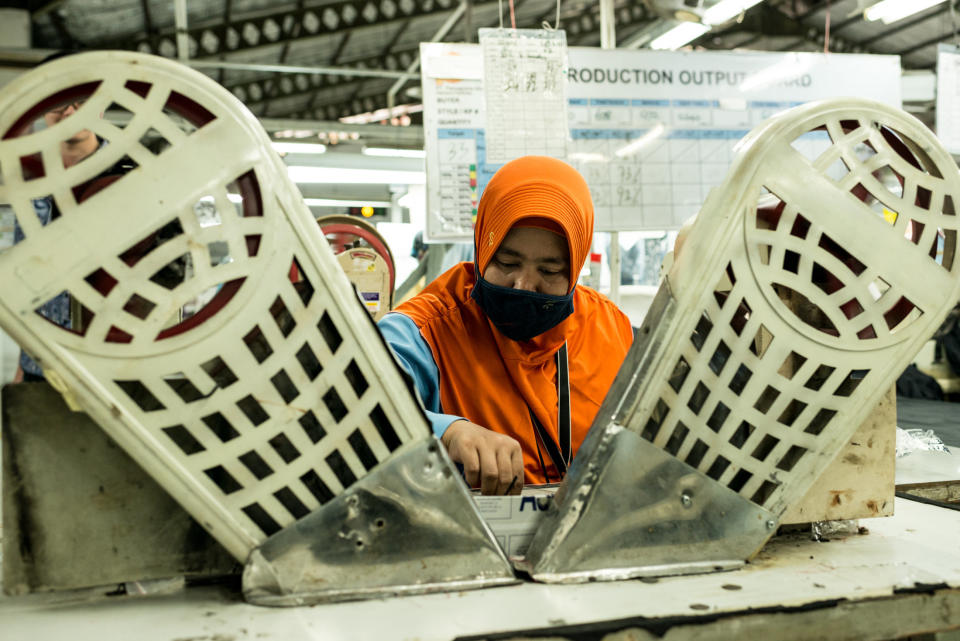 A worker sits at&nbsp;a machine for stitching buttons on jackets and pants, at&nbsp;Pan Brothers garment factory in Tangerang, Jakarta. (Photo: Elisabetta Zavoli for HuffPost)