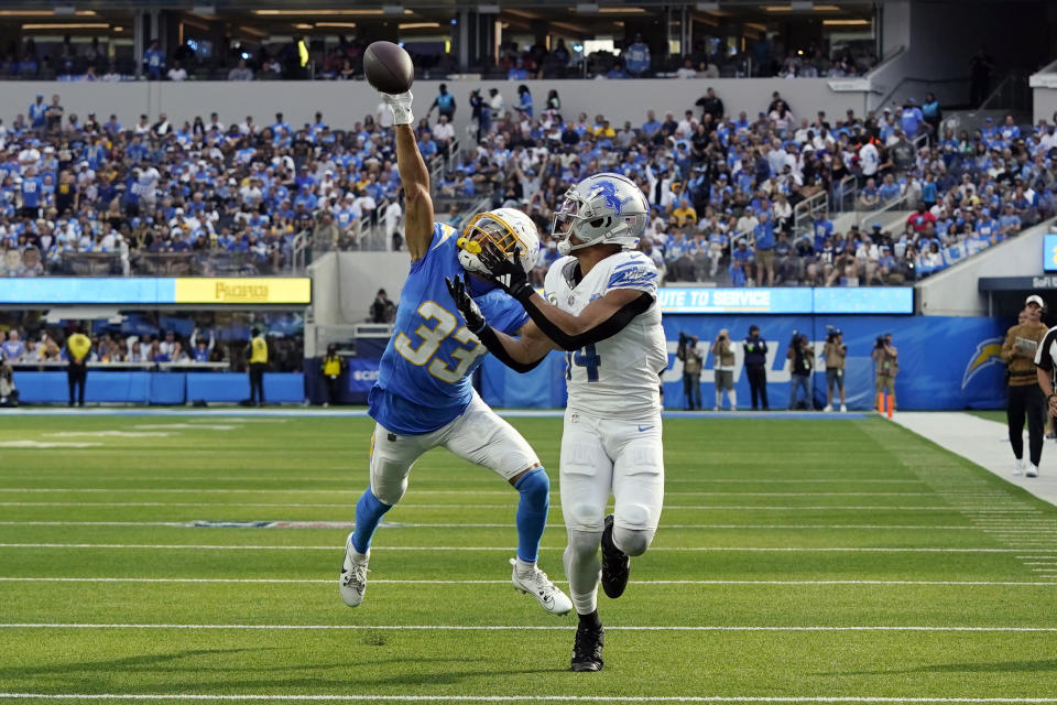 Los Angeles Chargers cornerback Deane Leonard (33) breaks up a pass intended for Detroit Lions wide receiver Amon-Ra St. Brown (14) during the first half an NFL football game Sunday, Nov. 12, 2023, in Inglewood, Calif. (AP Photo/Gregory Bull)