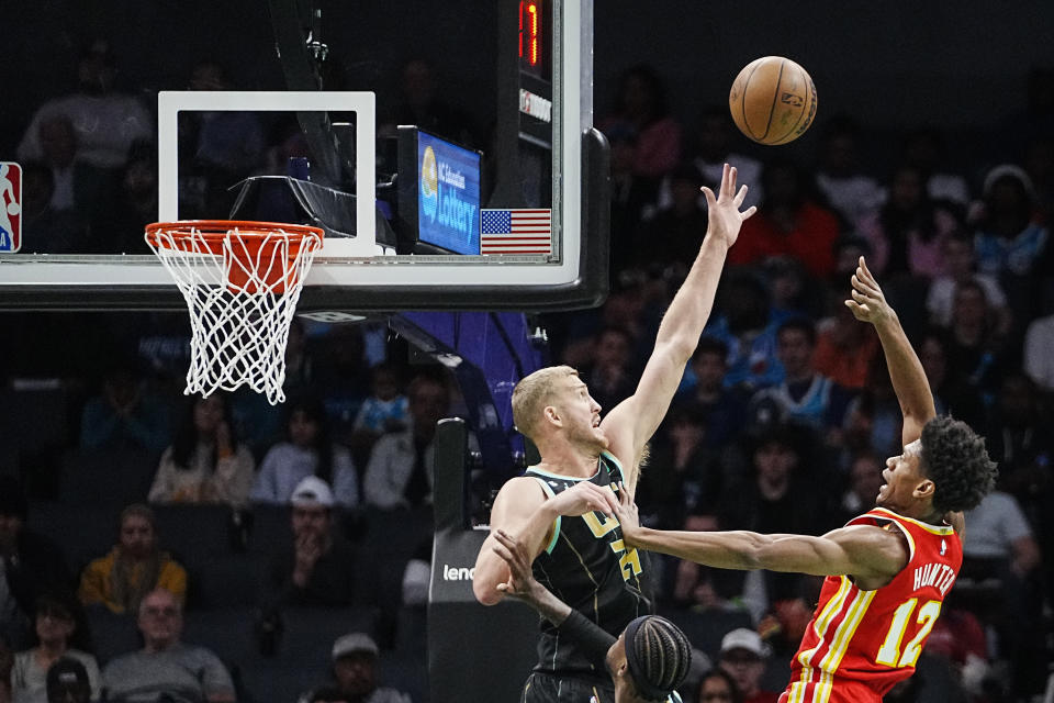 Charlotte Hornets center Mason Plumlee, top left, attempts to block a shot by Atlanta Hawks forward De'Andre Hunter, right, during the first half of an NBA basketball game Friday, Dec. 16, 2022, in Charlotte, N.C. (AP Photo/Rusty Jones)