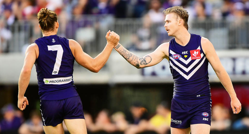 Seen here, former Fremantle teammates Nat Fyfe and Cam McCarthy high-fiving during an AFL game in 2018. 