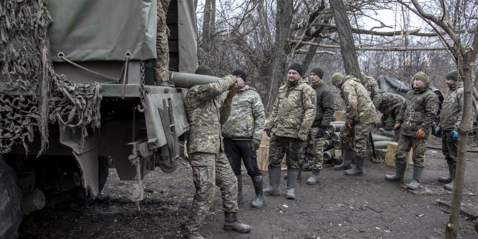 Ukrainian servicemen unload rounds of ammunition from a tank.