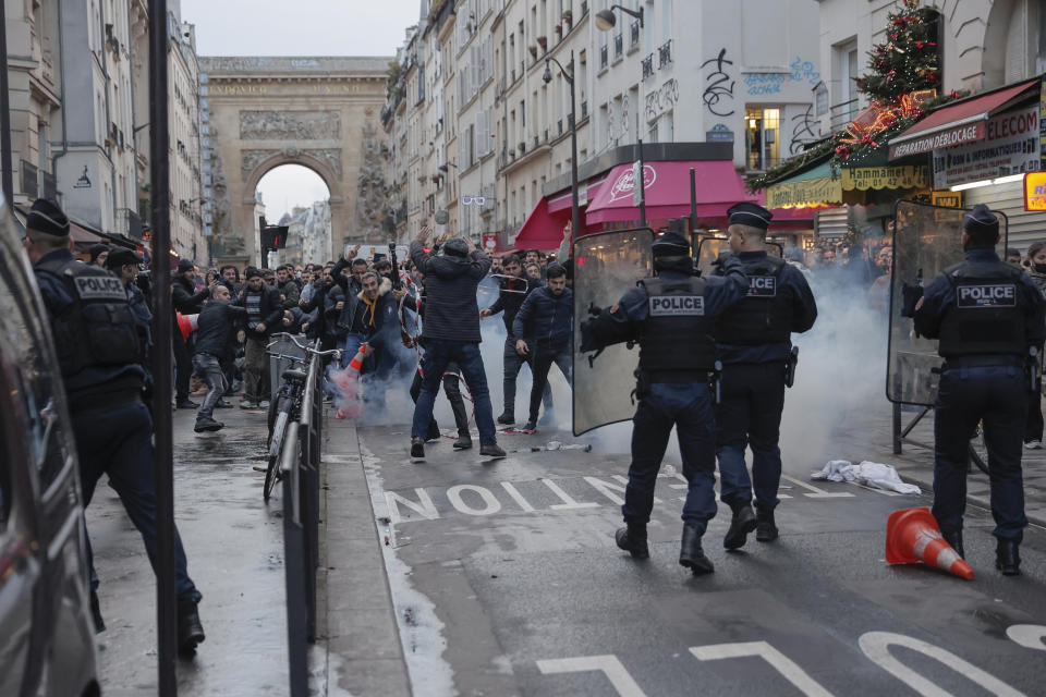 Miembros de la comunidad kurda se enfrentan con policías luego de un tiroteo en París, el viernes 23 de diciembre de 2022. (Foto AP/Lewis Joly)