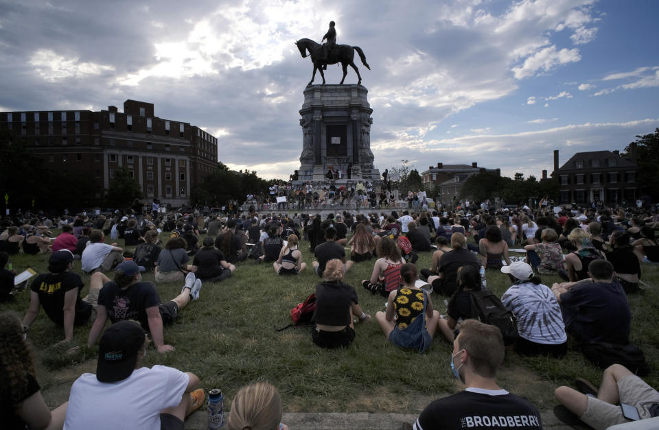 Protesters sit near the statue of Robert E. Lee on Monument Avenue in Richmond, Va., Wednesday, June 3, 2020. (Bob Brown/Richmond Times-Dispatch via AP)