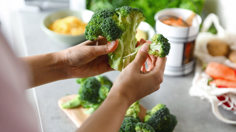 Person breaking apart broccoli florets