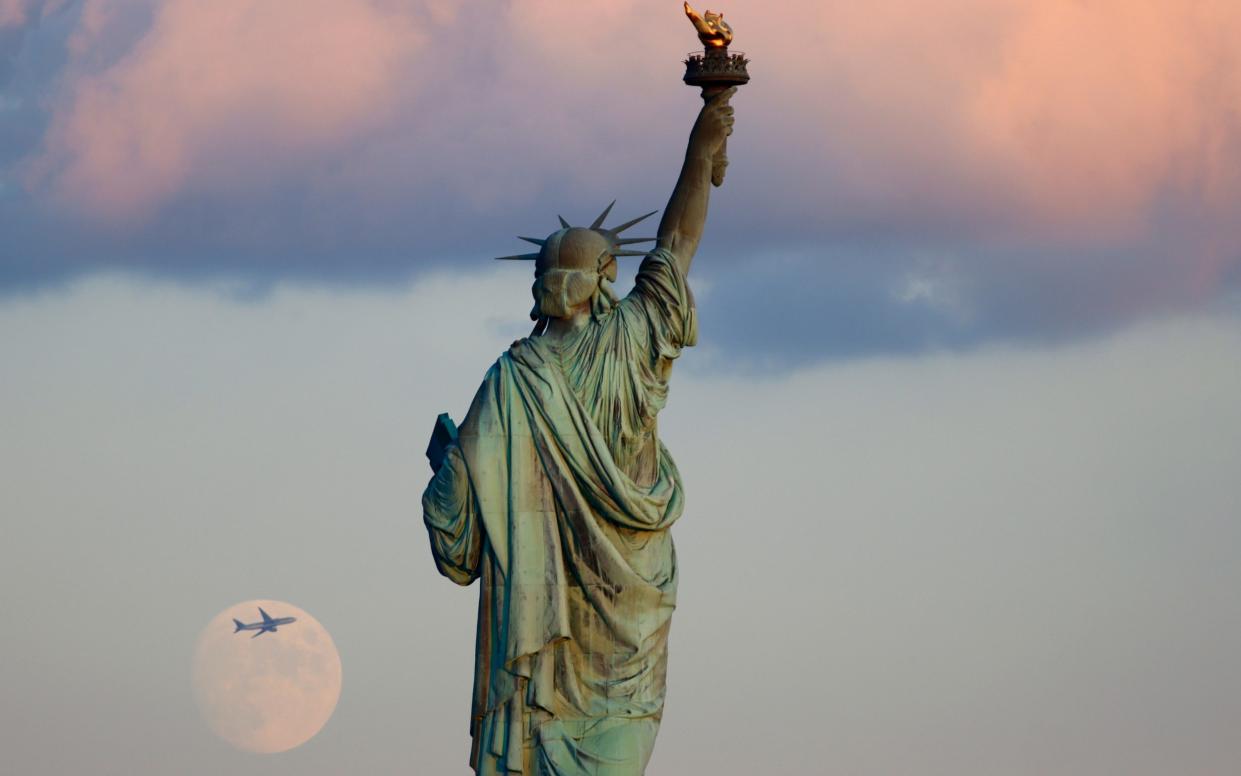  A 95 percent waxing crescent moon rises behind the Statue of Liberty in New York City - Gary Hershorn/Getty Images