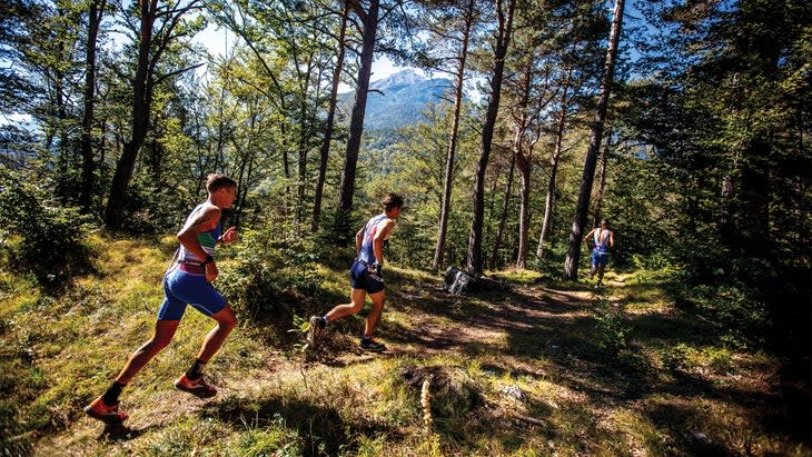 XTERRA competitors running through a forest in Italy