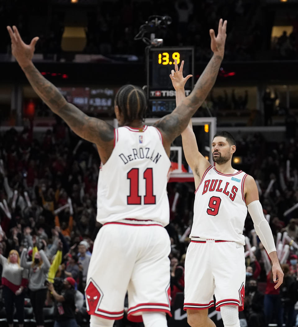 Chicago Bulls' Nikola Vucevic (9) and DeMar DeRozan celebrate Vucevic's three-point basket with 13.9 second remaining in the second half of an NBA basketball game against the Toronto Raptors Wednesday, Jan. 26, 2022, in Chicago. The Bulls won 111-105. (AP Photo/Charles Rex Arbogast)