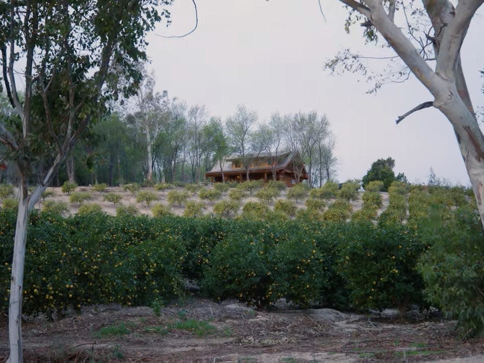 A home tucked behind land.