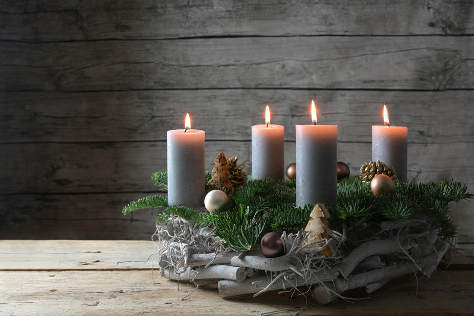 Rustikaler Adventskalender mit vier brennenden Kerzen
