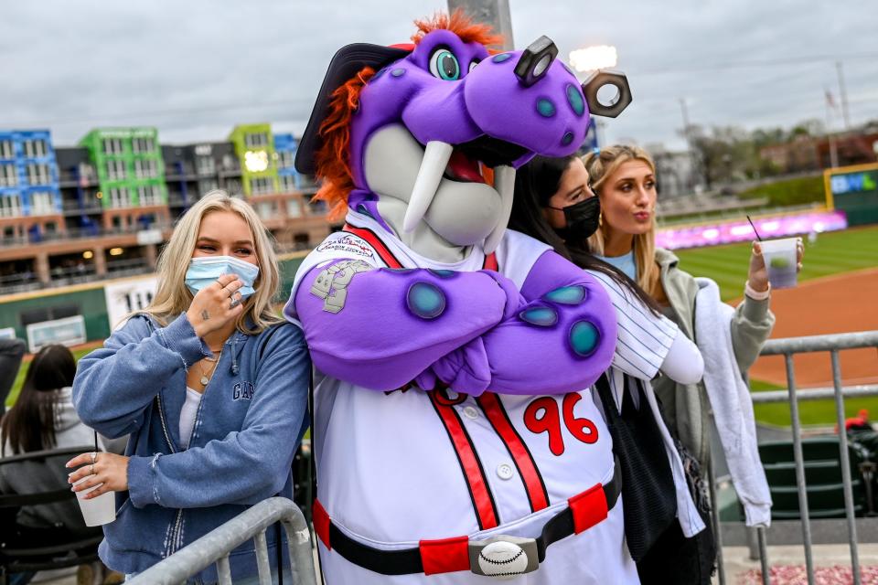 From left, Kate Notario, Jillian Mansour and Allie Mancall pose with Lugnuts mascot Big Lug before during opening night on Tuesday, May 4, 2021, at Jackson Field in Lansing.