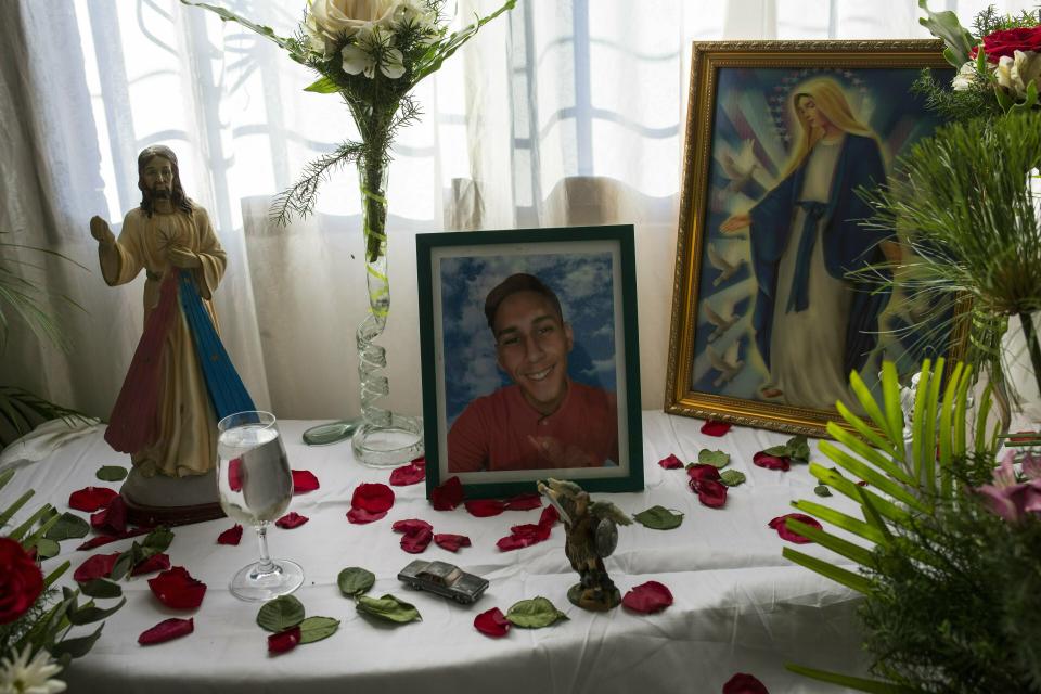 A portrait of Nick Samuel Oropeza sits on an altar at his family's home in Caracas, Venezuela, Sunday, Feb. 3, 2019. The 19-year-old's family says he was last seen alive on Jan. 23 fleeing alongside other anti-government protesters through Las Adjuntas slum as national guardsmen opened fire on people who had blocked streets with mounds of trash. (AP Photo/Rodrigo Abd)