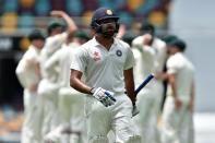 Indian batsman Rohit Sharma (C) leaves the ground as Australia's team celebrate his dismissal, on the second day of their 2nd Test match, at The Gabba in Brisbane, on December 18, 2014