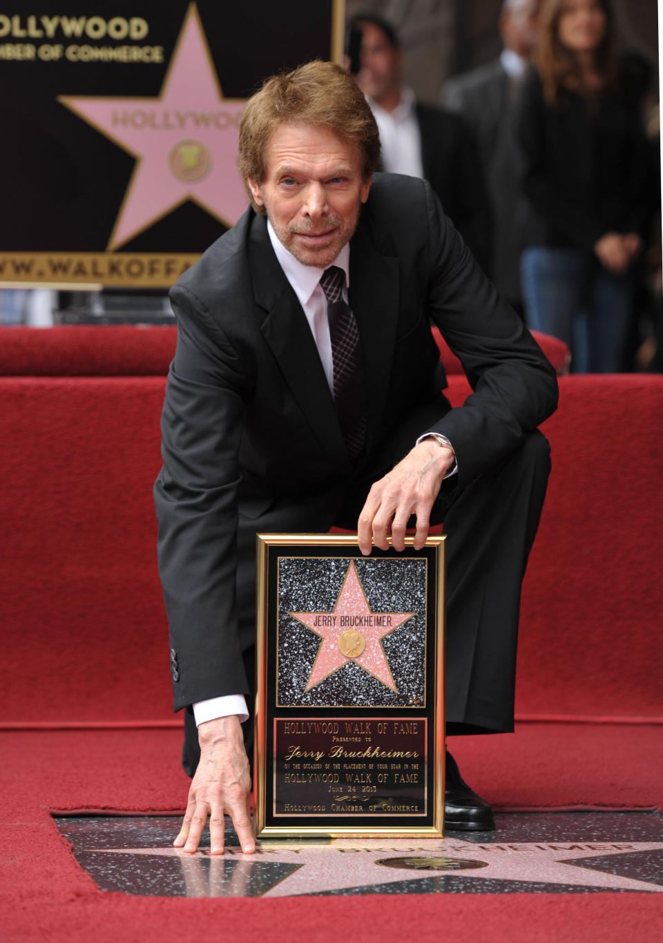 In this June 24, 2013 file photo, film producer Jerry Bruckheimer poses with his star on the Hollywood Walk of Fame in Los Angeles. After more than two decades with Disney, where he produced the juggernaut “Pirates of the Caribbean” and “National Treasure” film franchises among many box-office hits, Bruckheimer begins a new partnership with Paramount in March 2014. Bruckheimer continues his work in television, too, where he’s found groundbreaking success with the many “CSI” series and “The Amazing Race,” which has won 14 Emmy Awards. (Photo by John Shearer/Invision/AP, File)