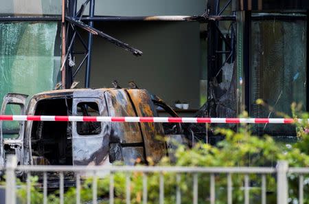 A van is seen burned out after crashing into the glass facade of the head office of Dutch newspaper De Telegraaf in what police said was a deliberate action in Amsterdam, Netherlands June 26, 2018. REUTERS/Piroschka van de Wouw