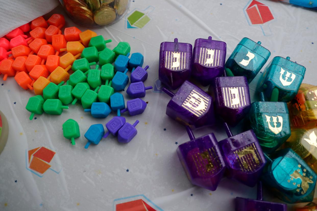 Dreidels wait to be spun on the table under the pavilion at Lake Ella during Chabad of Tallahassee's menorah lighting ceremony Sunday, Dec. 22, 2019. 