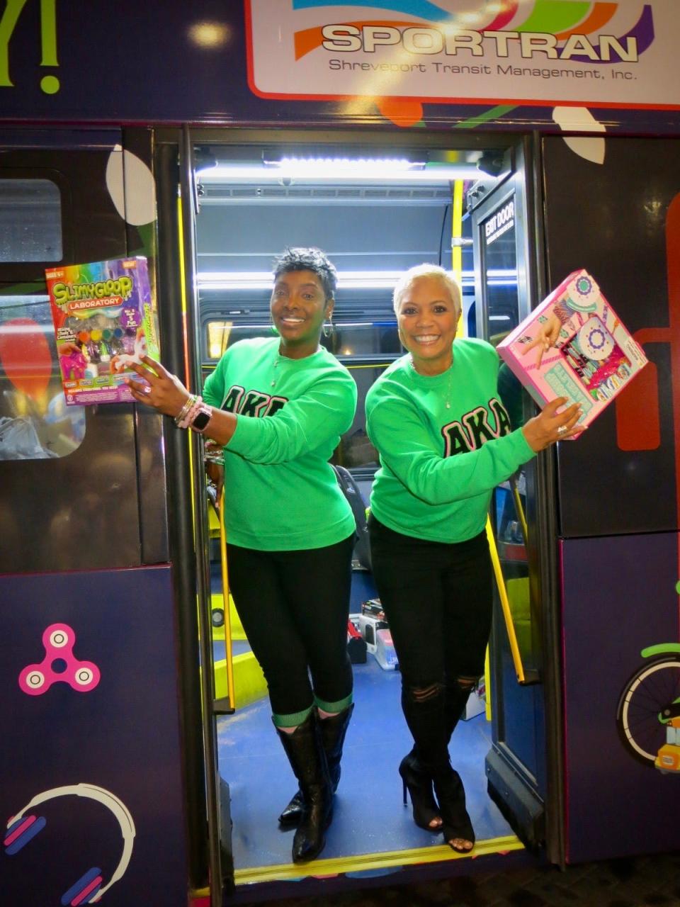 Tasha Cavanaugh and A. Tanley Washington, of Alpha Kappa Alpha sorority, show toys collected in the Stuff The Bus campaign.