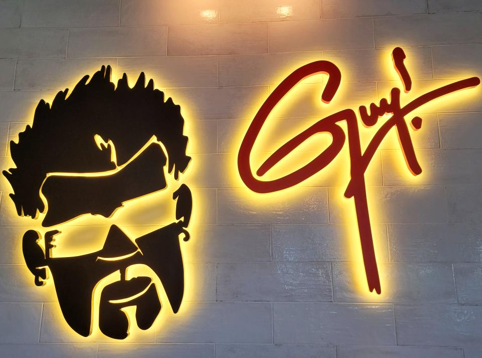 A sign in the bar at Guy Fieri's Kitchen + Bar in Council Bluffs features a cutout of Fieri's head.