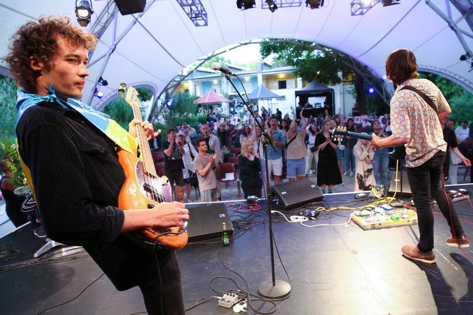 BERLIN, GERMANY - JUNE 29: Andrii Sukhariev of Love 'n' Joy wears a Ukrainian flag as he performs at a music event organized by Vitsche, a Ukrainian refugee assistance, activist and cultural organization, at ufaFabrik as part of the city's SommerKultur series of outdoor events, on June 29, 2022 in Berlin, Germany. Over seven million refugees have left Ukraine since the start of Russia's invasion four months ago in the largest mass population displacement in Europe since World War II, with an estimated 800,000 of them seeking permanent or temporary residence in Germany. (Photo by Adam Berry/Getty Images)