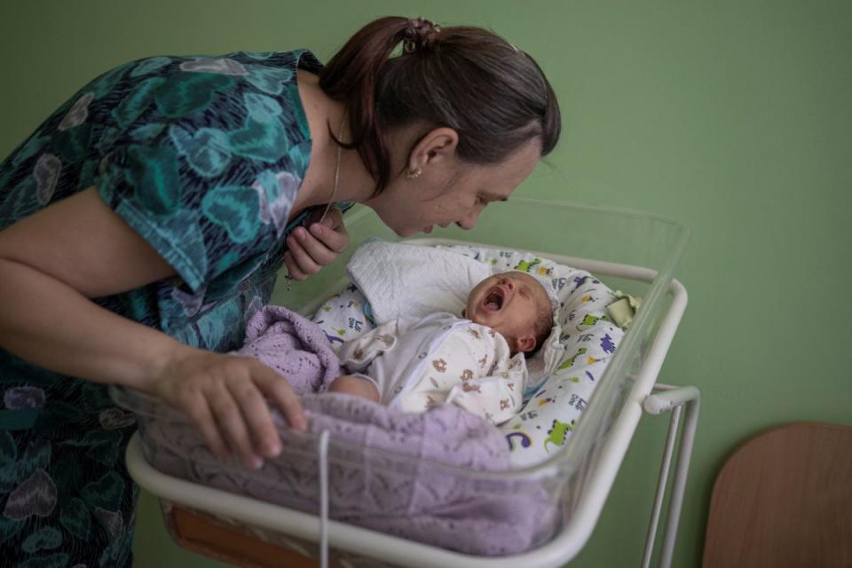 Elena checks on her baby, Mikhail (Reuters)