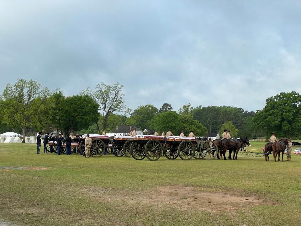 A funeral procession carries the flag-draped coffins holding the remains of fourteen Revolutionary War soldiers recently excavated on the Camden Battlefield. In April, the South Carolina Battleground Preservation Trust held three days of ceremonies to honor the fallen soldiers.