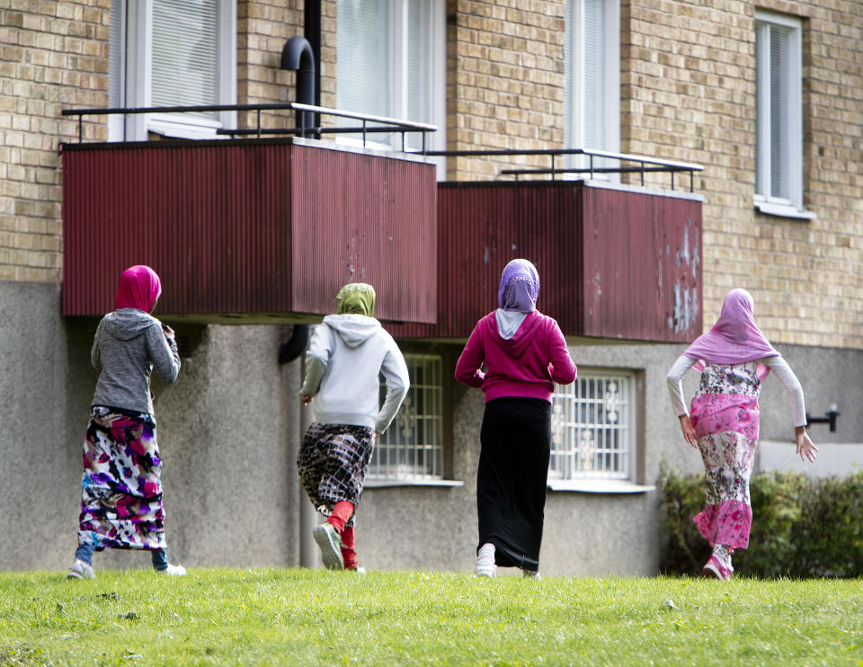 In this Aug. 30, 2018 photo migrant girls from Africa run along their apartment house in Flen, some 100 km west of Stockholm, Sweden. The town has welcomed so many asylum seekers in recent years that they now make up about a fourth of the population. (AP Photo/Michael Probst)