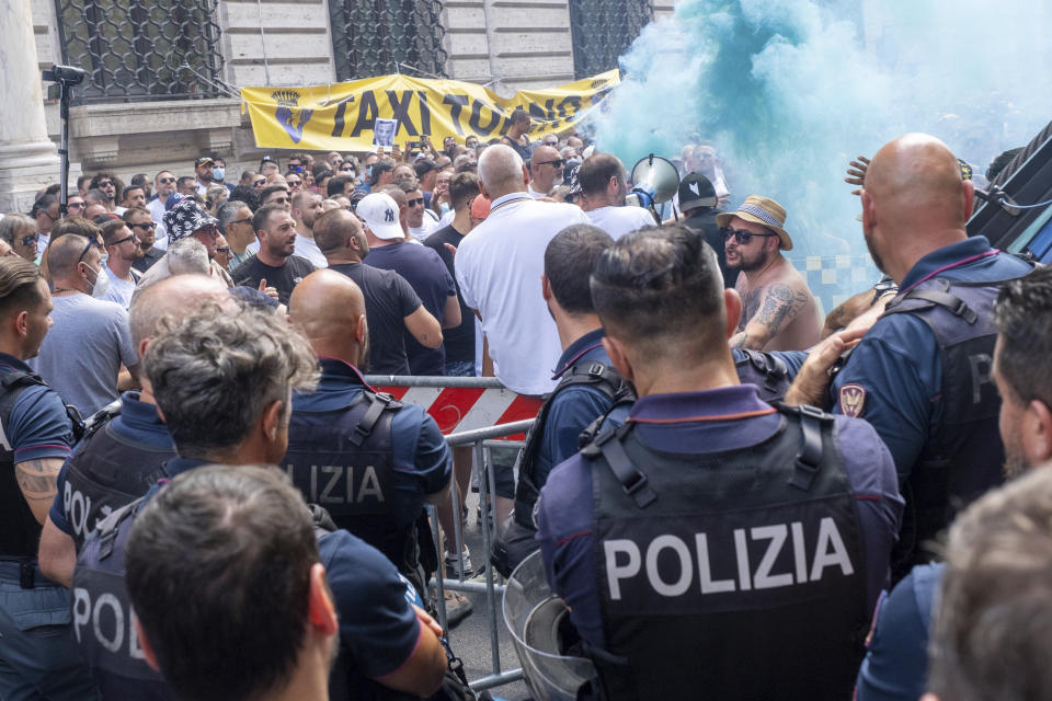 Hundreds of taxi drivers protest in front of Chigi Palace government offices in Rome, Wednesday, July 13, 2022. Taxi drivers left their cars idle for a second day to protest the Italian government's plans to allow more competition, including share-ride services. (Mauro Scrobogna /LaPresse via AP)