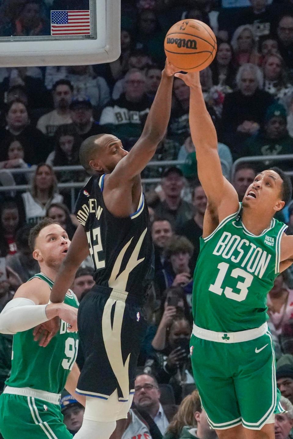 Milwaukee Bucks forward Khris Middleton (22) and Boston Celtics guard Malcolm Brogdon (13) fight for the rebound during the first half of their game Tuesday, Feb. 14, 2023, at Fiserv Forum in Milwaukee.