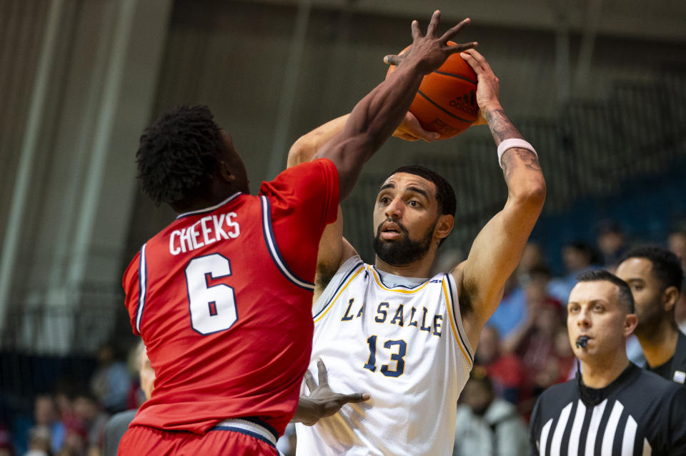 La Salle's Daeshon Shepherd, right, looks to pass with Dayton's Enoch Cheeks, left, defending during the second half of an NCAA college basketball game Tuesday, Jan. 23, 2024, in Philadelphia. Dayton won 66-54. (AP Photo/Chris Szagola)