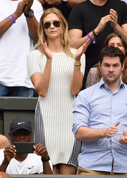 Karlie Kloss in a white T-shirt dress and Ray Bans.