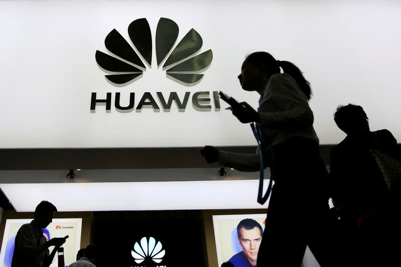 FILE PHOTO: People walk past a sign board of Huawei at CES (Consumer Electronics Show) Asia 2016 in Shanghai, China May 12, 2016. REUTERS/Aly Song/File Photo