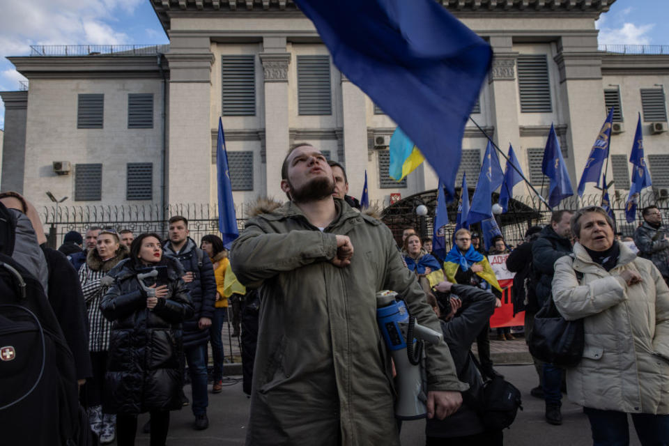 People sing the Ukrainian national anthem during a protest outside the Russian Embassy in Kyiv, Ukraine. 