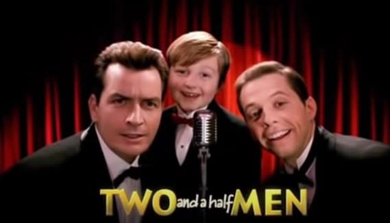 A boy and two men sing into a microphone with the title card "Two and a half Men"