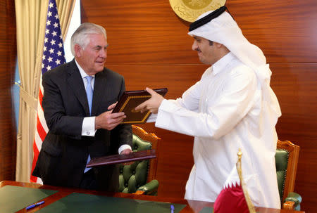 Qatar's foreign minister Sheikh Mohammed bin Abdulrahman al-Thani (R) and U.S. Secretary of State Rex Tillerson exchange a memorandum of understanding in Doha, Qatar, July 11, 2017. REUTERS/Naseem Zeitoon