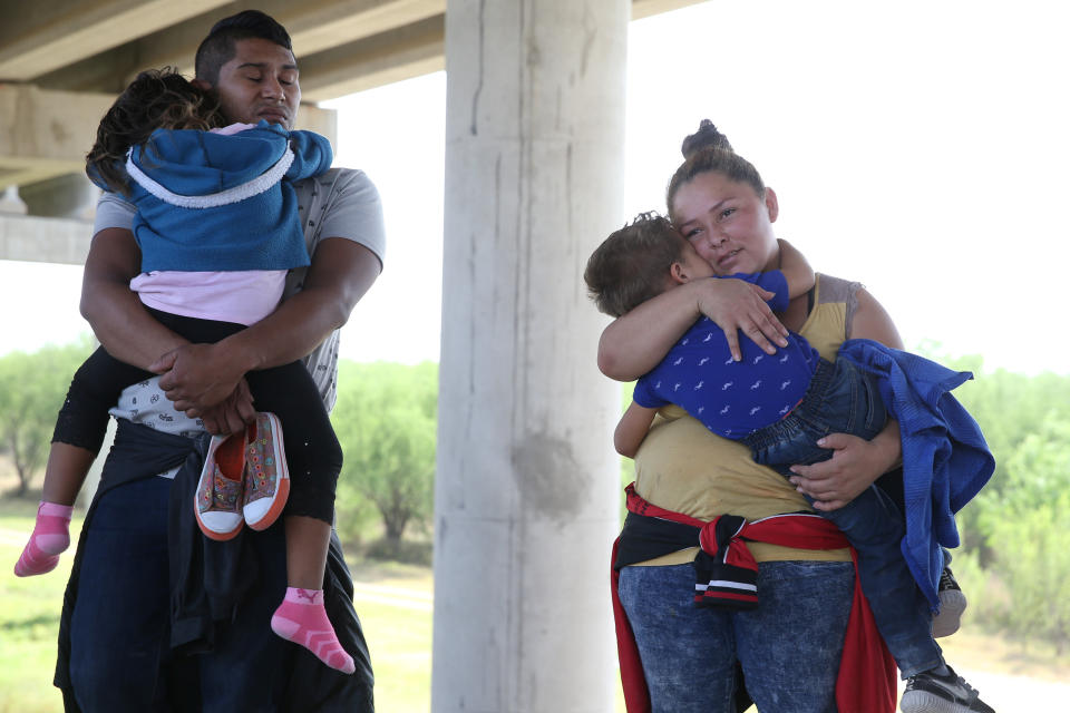 Adults and children await processing near McAllen, Texas, on April 2, 2018.