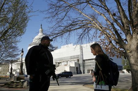 United States Capitol police officer Harry Dunn (L) checks identification from a pedestrian in front of the U.S. Capitol in Washington March 29, 2016. REUTERS/Gary Cameron