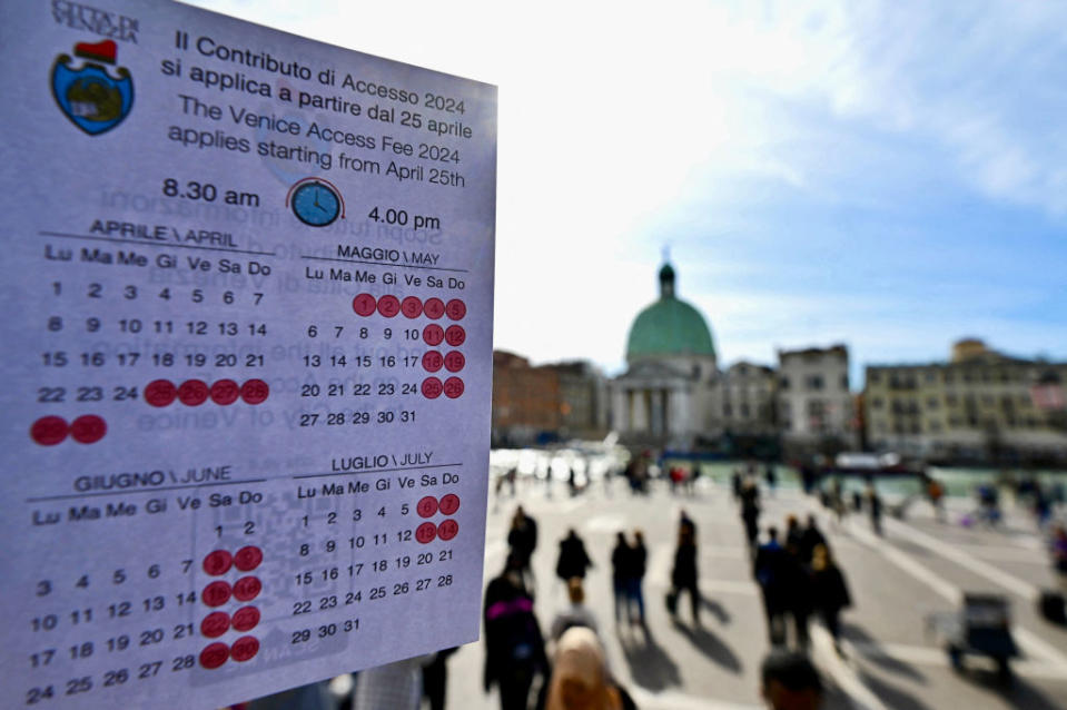 A calendar shows the days visitors will have to pay to access Venice, in front of Santa Lucia train station on April 19, 2024. <span class="copyright">Gabriel Bouys—AFP/Getty Images</span>