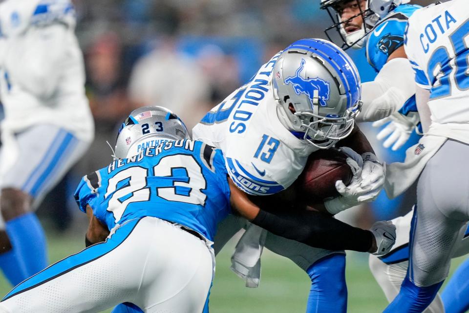 Lions running back Craig Reynolds is tackled by Panthers cornerback CJ Henderson during the first quarter of the 26-17 preseason win over the Panthers on Friday, Aug. 25, 2023, in Charlotte, North Carolina.