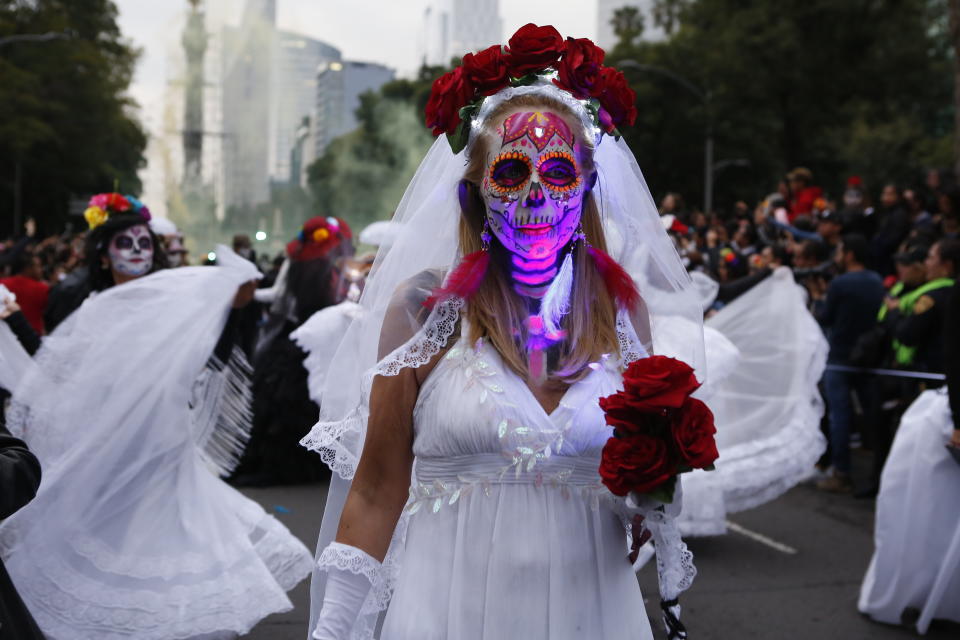 People dressed as Catrinas parade down Mexico City's iconic Reforma avenue during celebrations for the Day of the Dead in Mexico, City, Saturday, Oct. 26, 2019. (AP Photo/Ginnette Riquelme)