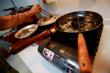 Fu Liting prepares to cook slices of fish with a handmade wok at her house in Beijing, China October 18, 2018. REUTERS/Thomas Suen