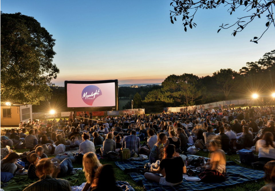 Crowds of seated fans in a park watching Moonlight Cinema sessions from $20 a session